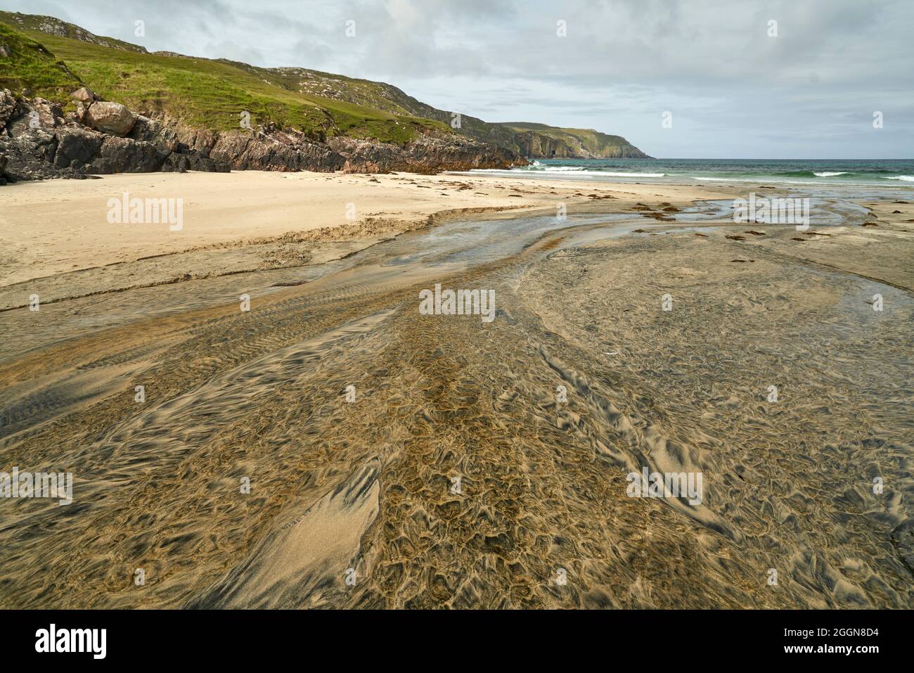 Détails fluviaux sur une plage où la tourbe est lavée dans le sable et la marée crée de beaux motifs. Reef Beach dans l'île de Lewis. Banque D'Images