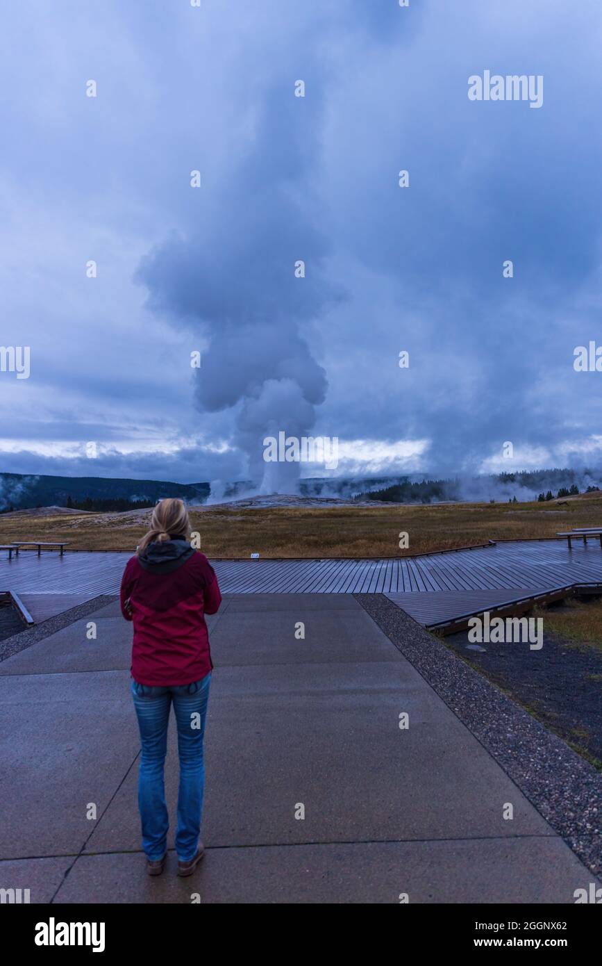 Parc national de Yellowstone, Wyoming - 20 août 2021 : une femme se tenant à l'observation de l'éruption du vieux Geyser fidèle tôt le matin Banque D'Images