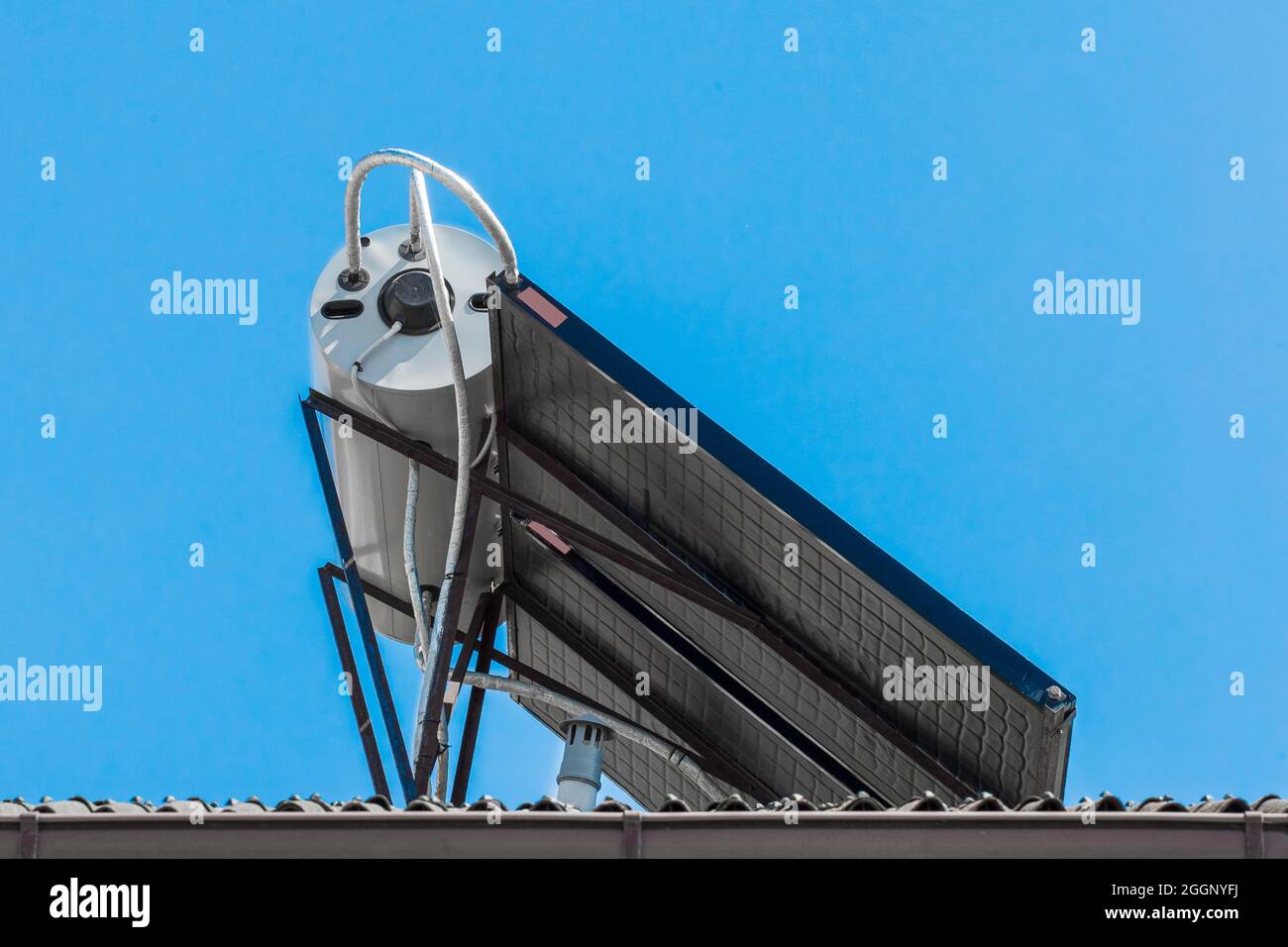 Panneaux solaires et technologies modernes de chauffage de l'eau système de collecte sur le toit du bâtiment sur fond de ciel bleu. Banque D'Images