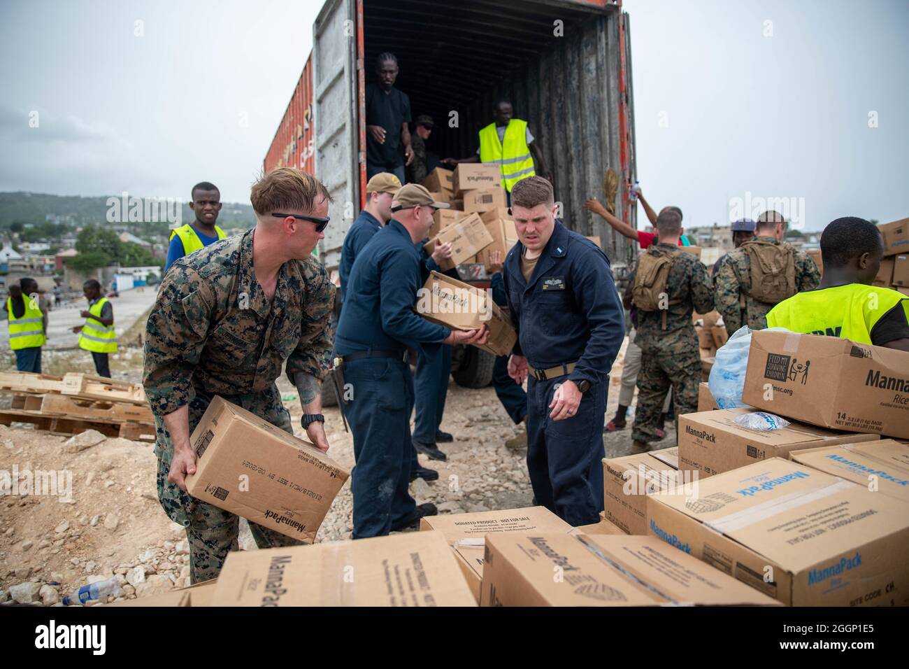 Les marins américains et les marins de la Force opérationnelle conjointe Haïti (foi-Haïti) et les bénévoles aident à décharger des boîtes pour redistribution à Port de Jeremie, Haïti, le 31 août 2021. Les Marines et les marins à bord de l'USS Arlington (LPD 24) ont travaillé à l'appui de la foi-Haïti pour une mission d'aide humanitaire et de secours en cas de catastrophe. (É.-U. Photo du corps marin par Cpl. Alize Sotelo) Banque D'Images