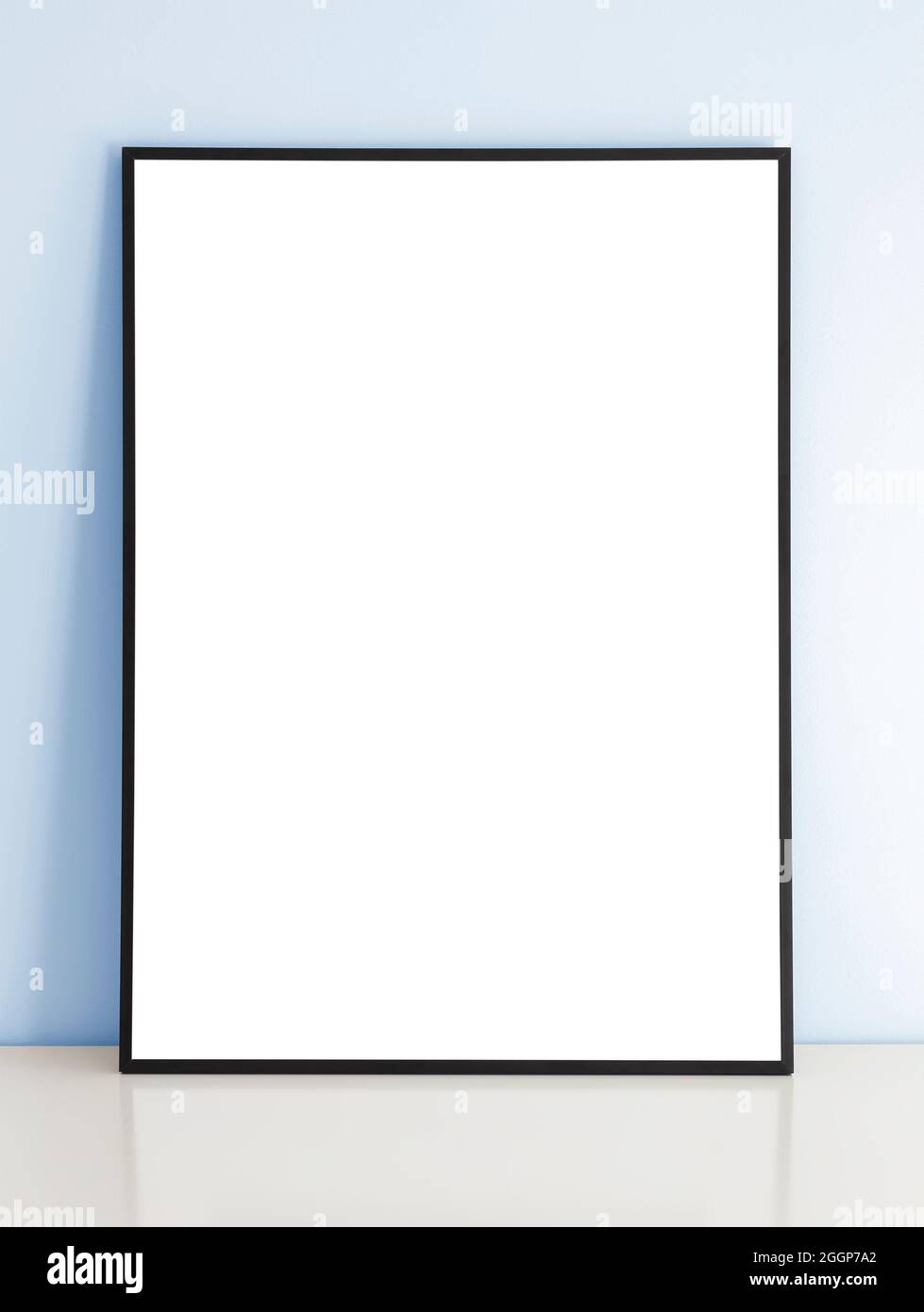 Cadre de maquette noir fin sur table avec mur bleu. Banque D'Images