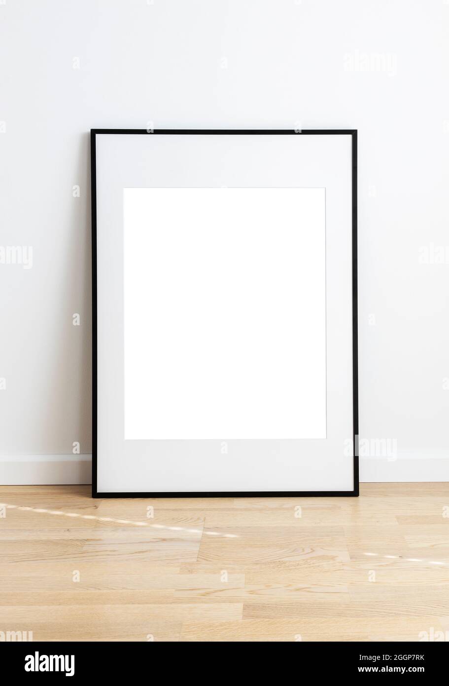Maquette rectangulaire debout dans une chambre avec parquet et mur blanc. Banque D'Images