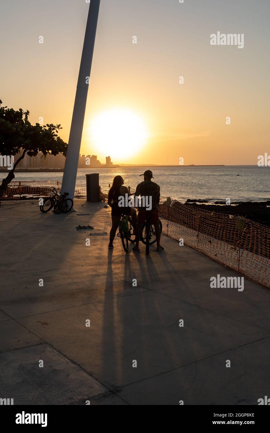 Jeune couple cycliste appréciant le coucher du soleil à Fortaleza Ceara Brésil Banque D'Images