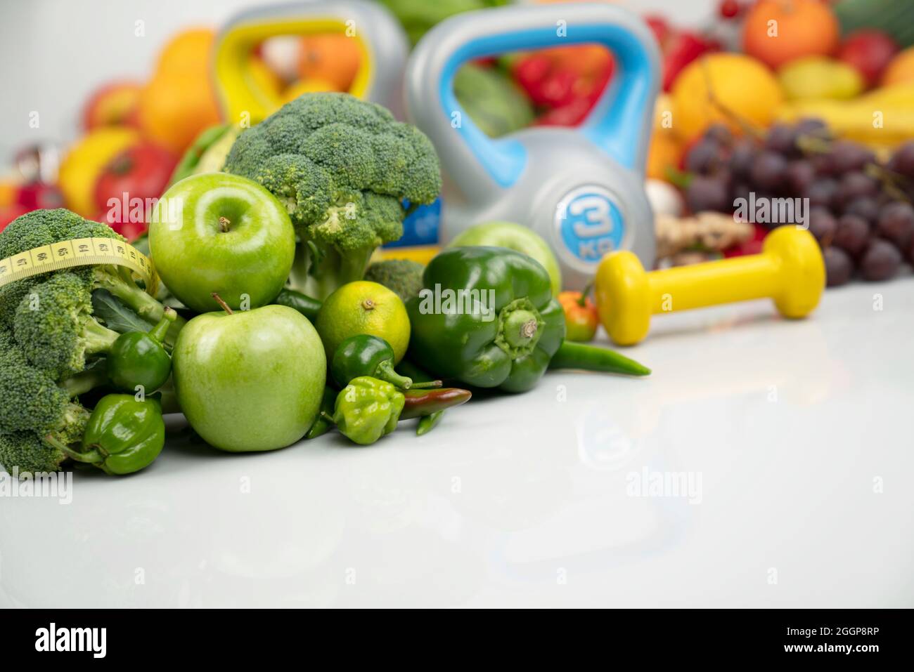 Concept de fitness. Alimentation saine : fruits et légumes. Équipement pour  les exercices de fitness: Appareil de pesage et haltères. Arrière-plan  blanc Photo Stock - Alamy