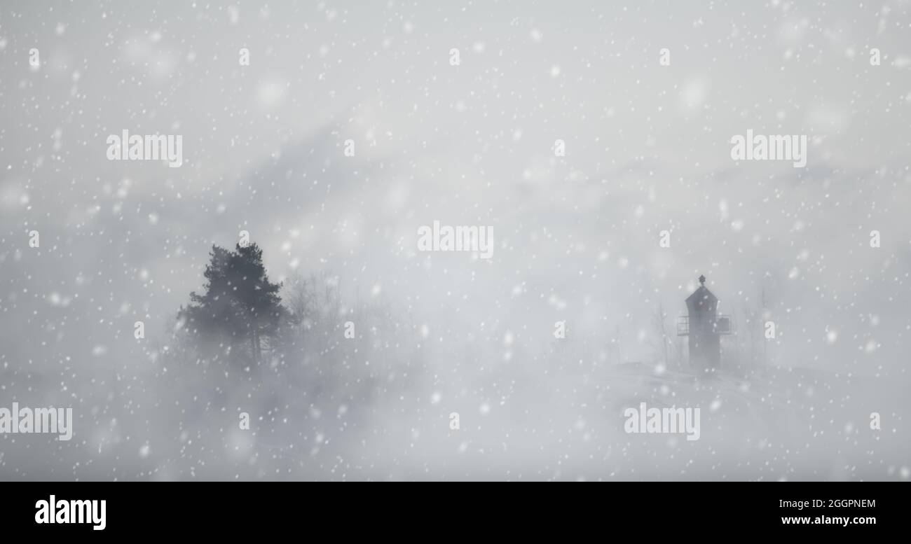 Petit phare et un arbre dans une tempête de neige avec un épais brouillard autour des deux. Neige créée par un logiciel de montage. Banque D'Images