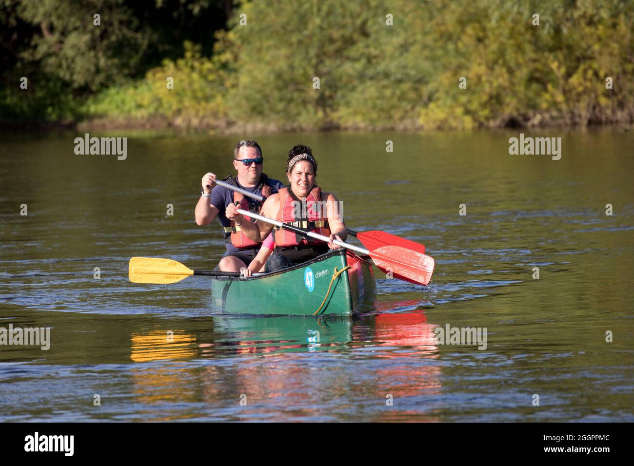 Couple canoë-kayak en canoë vert canadien sur River Wye à Hoarwithy, Herefordshire, Royaume-Uni Banque D'Images
