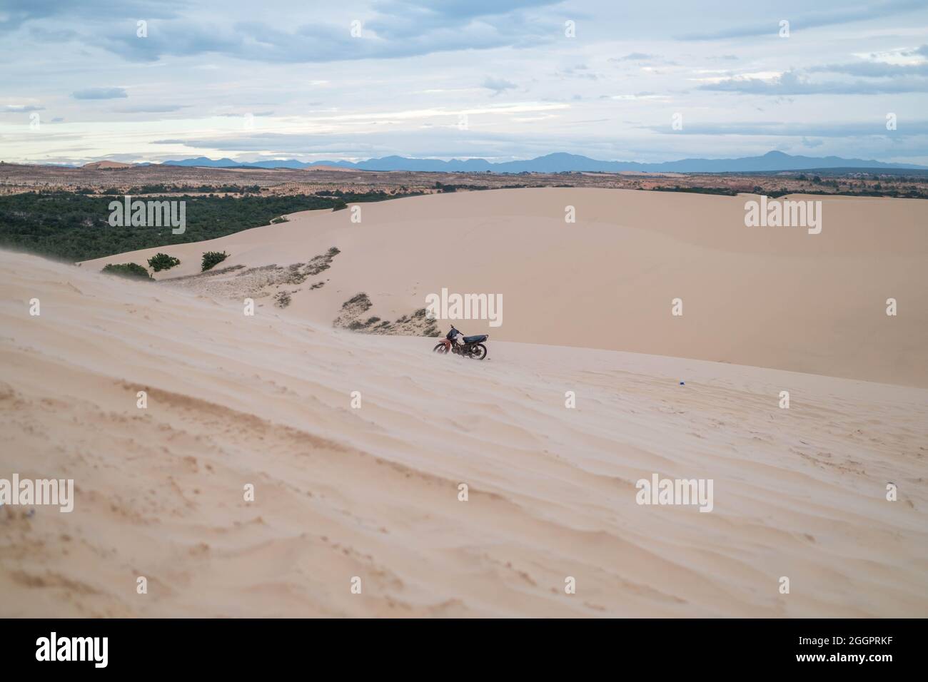 Vue pittoresque de la moto garée sur les dunes de sable dans le désert. Journée ensoleillée pendant les vacances d'été. Dunes de sable. Moto dans le désert. Banque D'Images