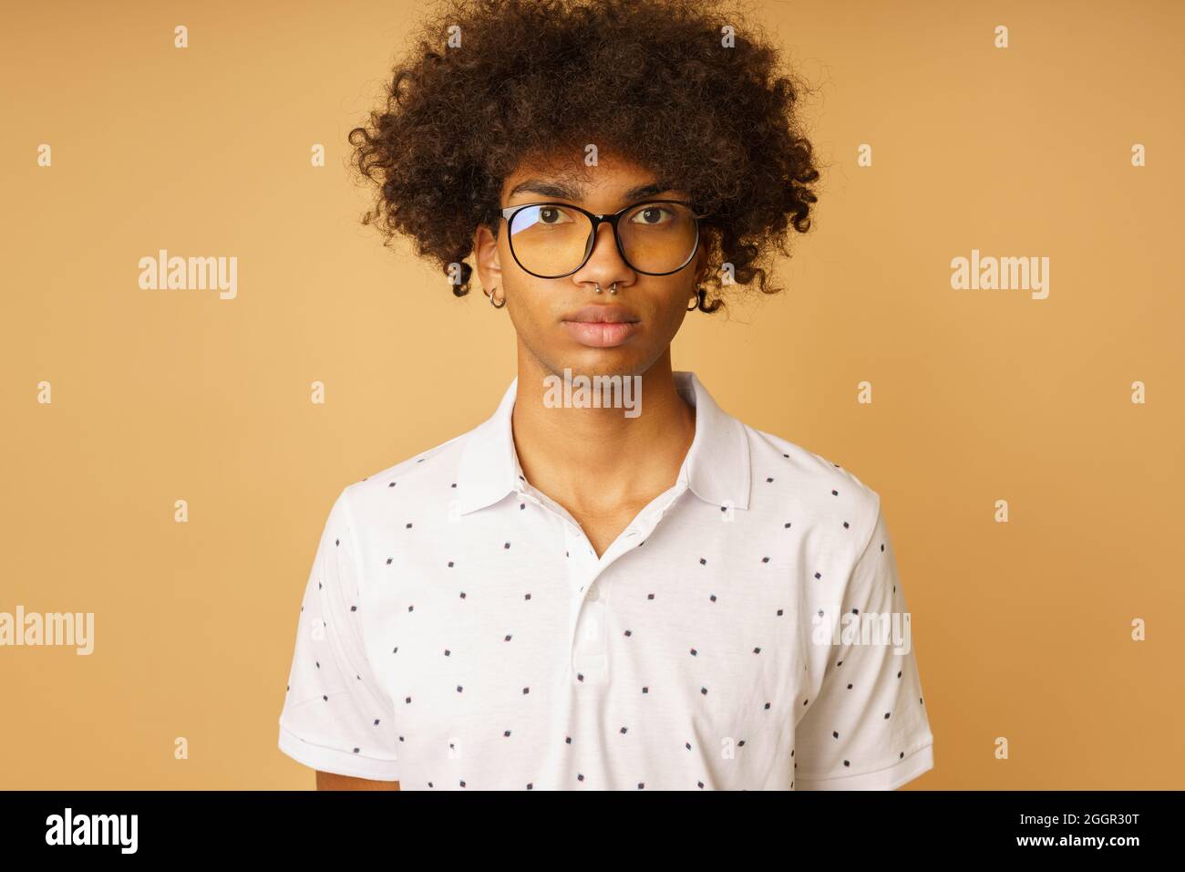 Homme afro sérieux avec des lunettes et le piercing Banque D'Images