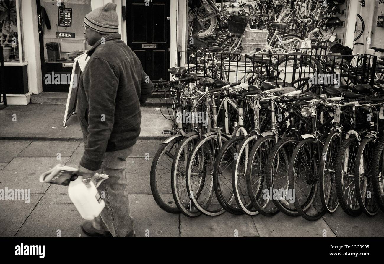 Un homme passe devant une boutique de vélos Banque D'Images