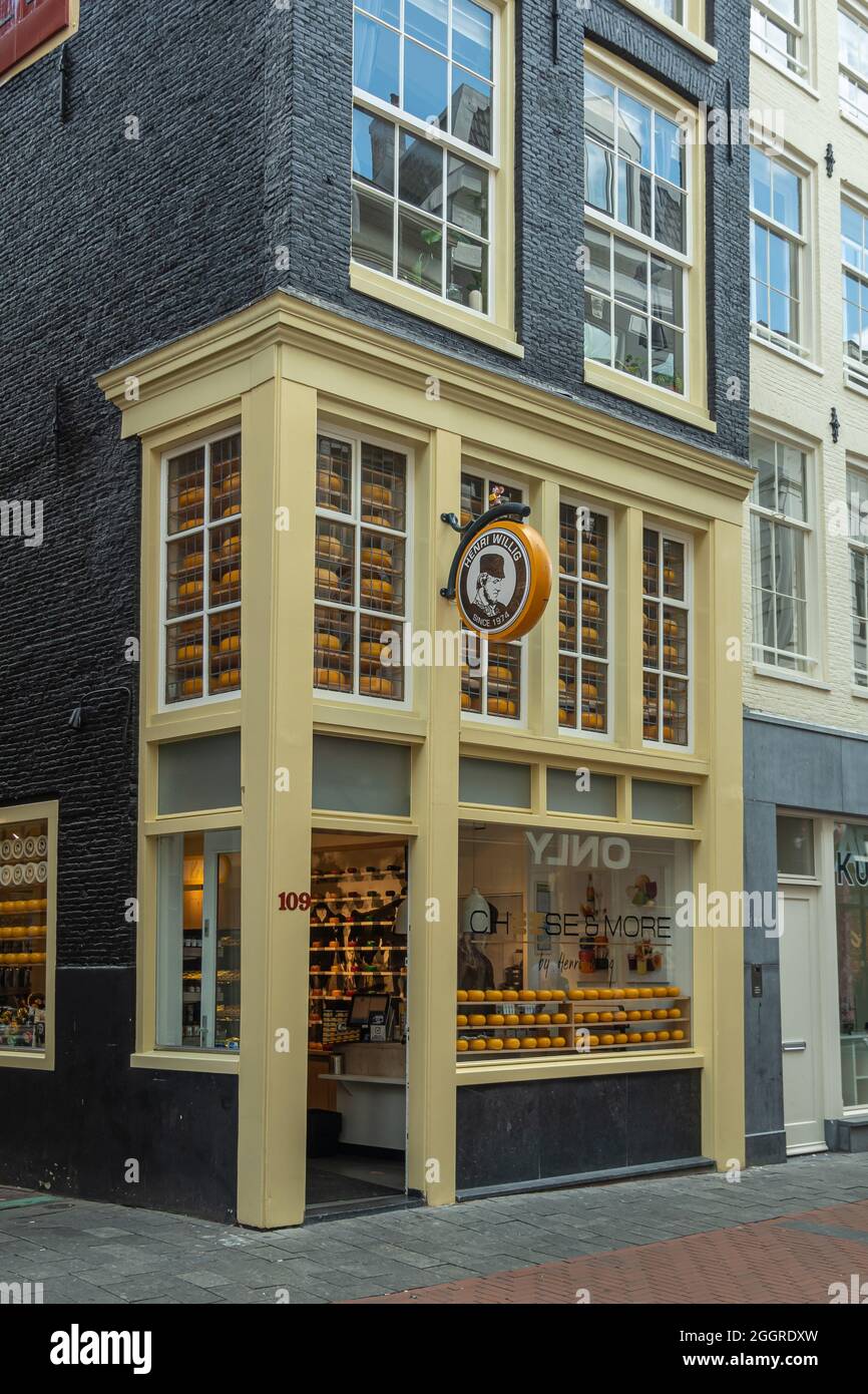 Amsterdam, pays-Bas - 14 août 2021 : la maison noire à cadre jaune est la fromagerie Henri Willig à l'angle de Haringpakkerssteeg. Beaucoup de fromages di Banque D'Images