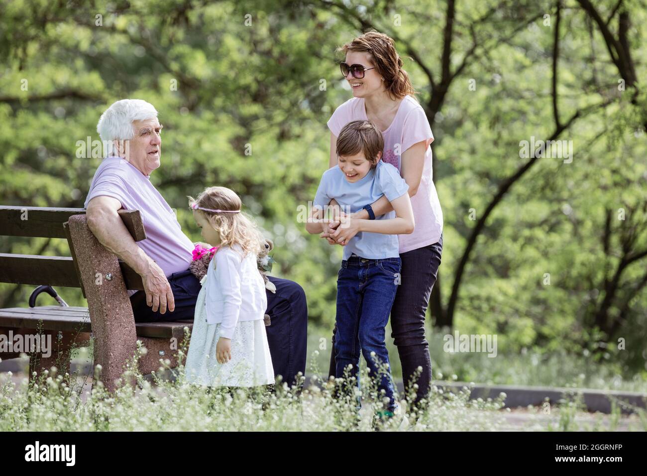 Famille de trois générations dans le parc d'été : grand-père, mère et petits-enfants. Bonne famille à l'extérieur. Banque D'Images