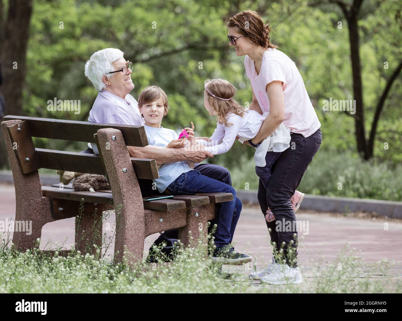 Famille de trois générations dans le parc d'été : grand-père, mère et petits-enfants. Bonne famille à l'extérieur. Banque D'Images
