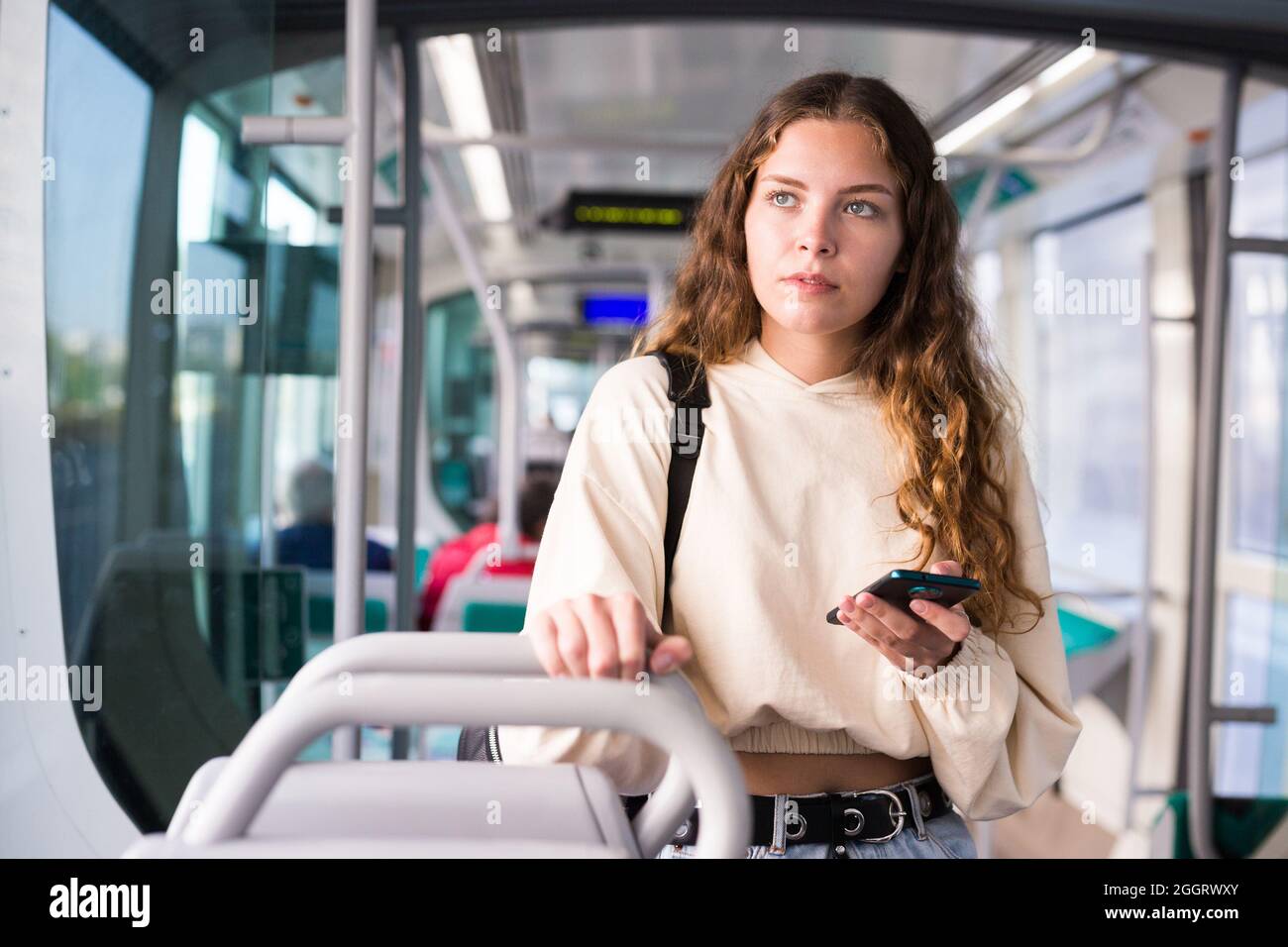 Jeune femme utilisant un smartphone en tram Banque D'Images