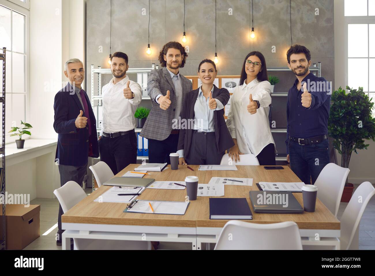 Une équipe d'employés heureux qui se tiennent debout au bureau après une réunion d'entreprise Banque D'Images
