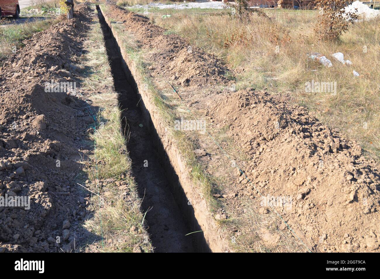Creuser une tranchée. Travaux de terrassement, creusement de tranchées. Longue tranchée de terre