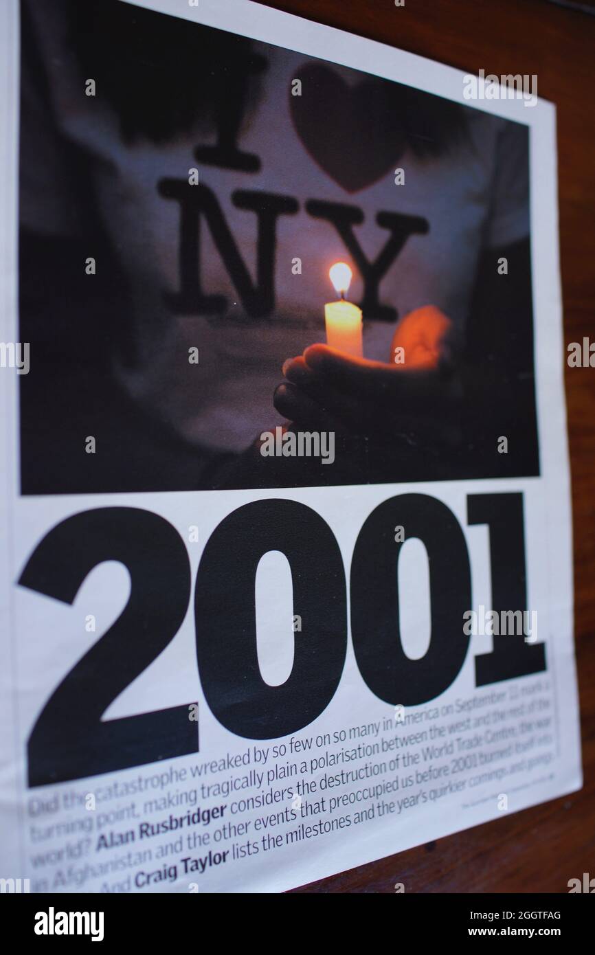 11 septembre 2001 - article de magazine avec photographie de la main tenant la bougie pendant une veillée pour commémorer les victimes des attaques terroristes de 9 11 en Amérique, 2001. Supplément week-end journal gardien : l'année en images avec essai par Alan Rusbridger Banque D'Images