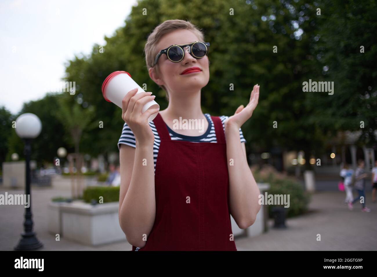femme aux cheveux courts dans la rue portant des lunettes de soleil Photo  Stock - Alamy