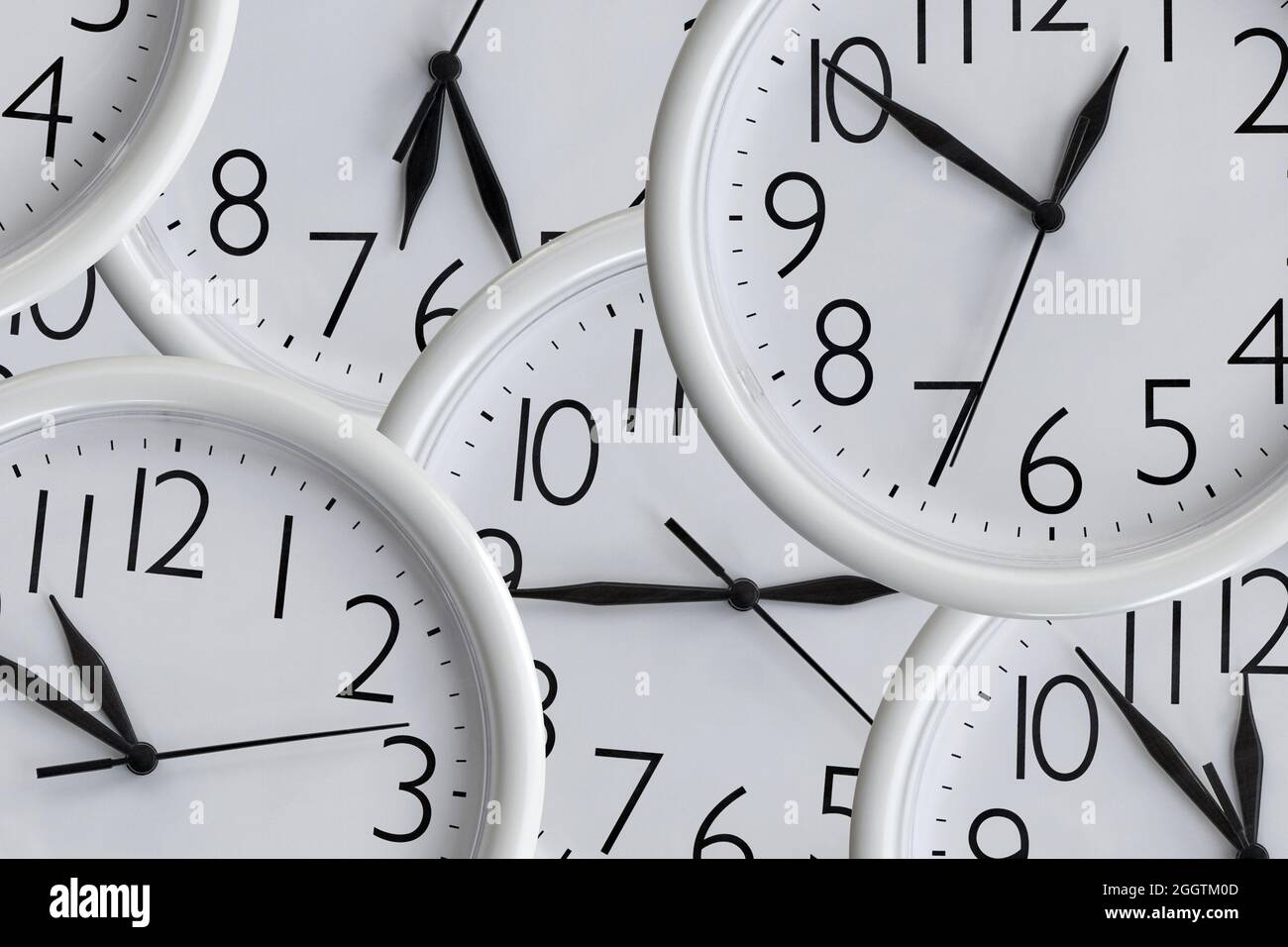 Arrière-plan de l'ensemble d'horloges de bureau rondes analogiques blanches de différentes tailles montrant différentes heures Banque D'Images