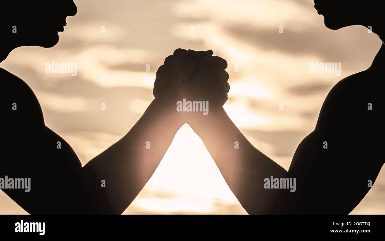 Silhouette de mains qui rivalisent en force. Rivalité, gros plan de lutte de bras mâle. Hommes mesurant les forces, les bras. Deux hommes lutte bras. Rivalité, vs Banque D'Images