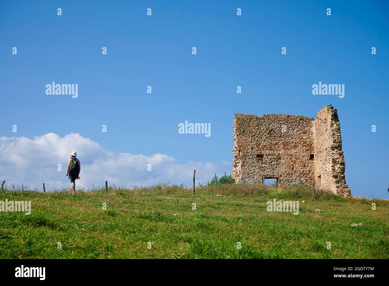 Femme d'âge moyen avec chapeau de paille et sac à dos à pied près de la tour San Telmo, Santa Justa, Santillana del Mar, Cantabria, Espagne, Europe Banque D'Images