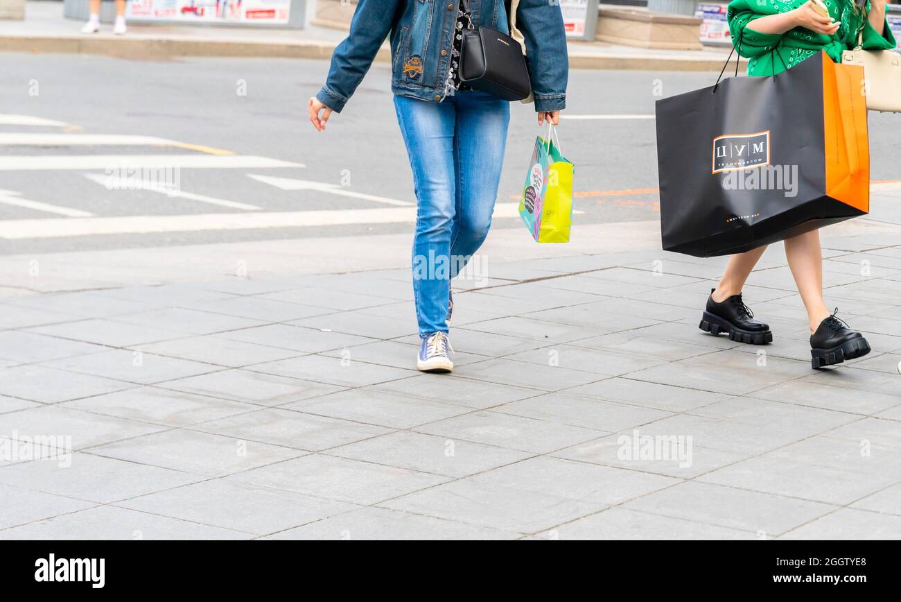 Une femme portant un grand sac de magasin TSUM tout en marchant, Moscou, Russie.Concept-consumérisme, économie de consommation, dépenses de consommation. Banque D'Images