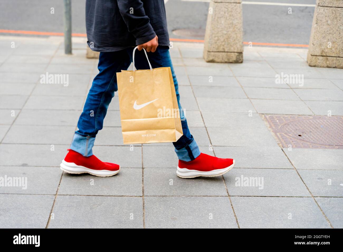 Un homme en jeans et chaussures rouges portant un sac Nike lors de la marche, Moscou, Russie.Concept-consumérisme, économie de consommation, dépenses de consommation. Banque D'Images