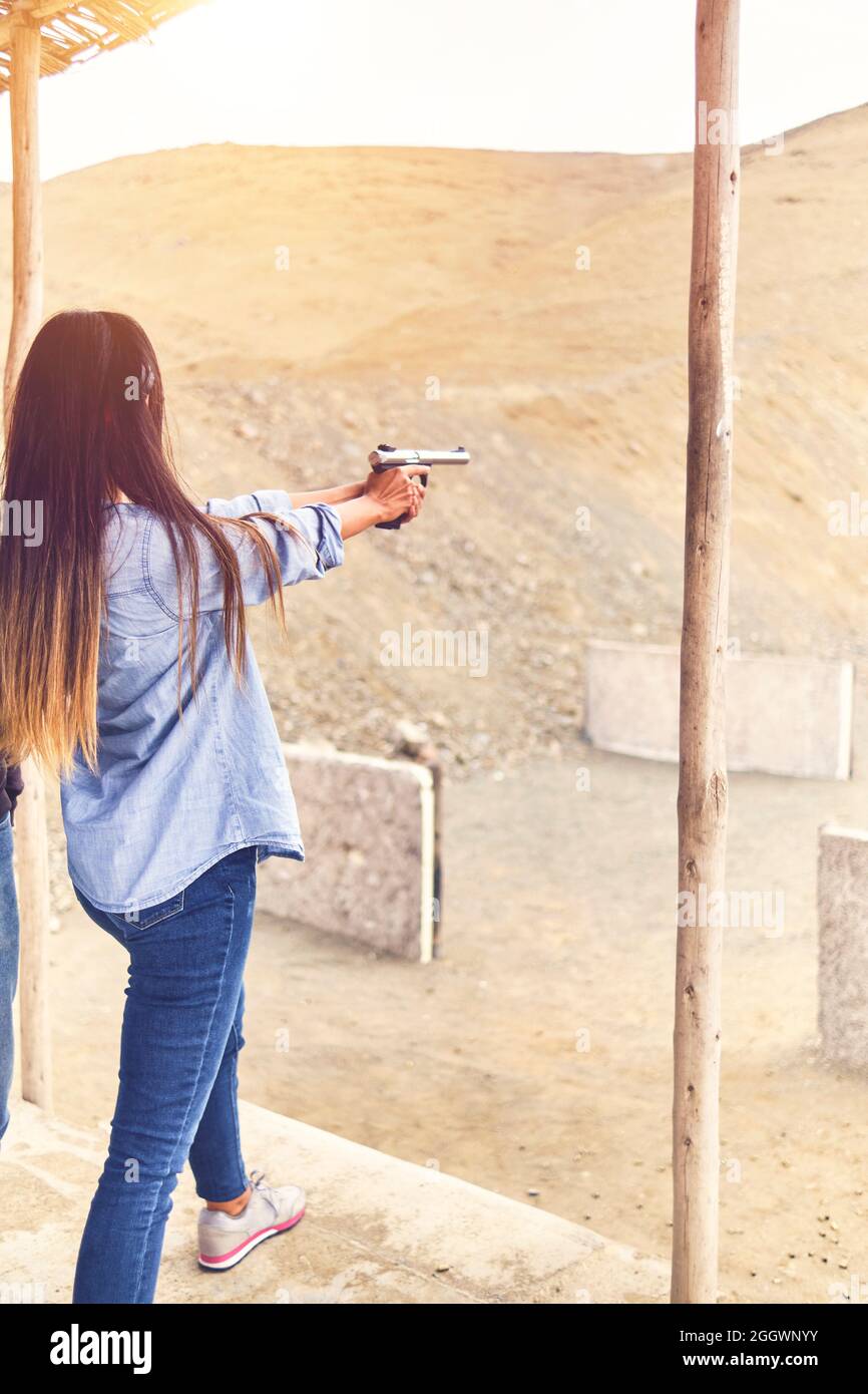 Femme libérant le stress, instructeur aidant la femme avec le pistolet Banque D'Images