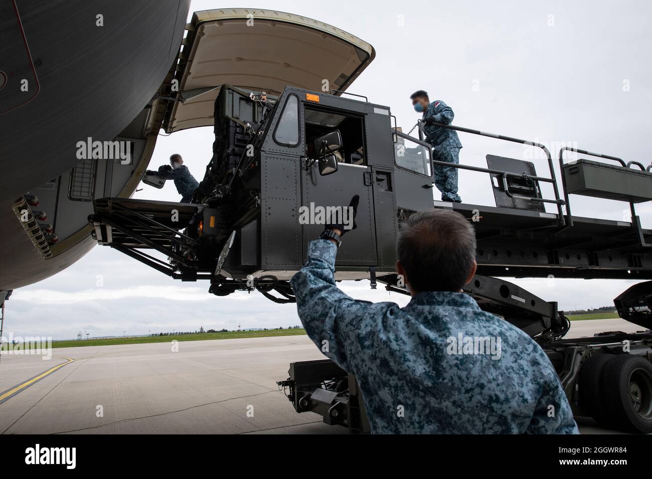 Guide du personnel de la Force aérienne de la République de Singapour Sgt. Jordan Gilchrist, 726e Escadron de mobilité aérienne superviseur des services d'aéronefs, lorsqu'ils chargent du fret sur un avion de transport de camion-citerne multirôle RSAF A330 à l'aide d'un chargeur de fret Tunner 60K sur la base aérienne de Spangdahlem, Allemagne, le 29 août 2021. Les membres des Forces armées de Singapour, arrivés à Spangdahlem AB le 27 août, se sont alliés à des aviateurs de la 52e Escadre de chasseurs et de la 726e AMS pour apporter un soutien supplémentaire aux opérations d'évacuation en Afghanistan. Les visages des membres de la RSAF étaient flous en termes de sécurité. (É.-U. Photo de la Force aérienne par Tech Banque D'Images