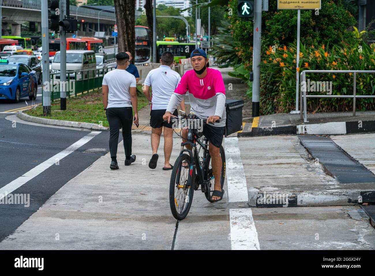 SINGAPOUR, SINGAPOUR - 30 août 2021 : homme de livraison de canda alimentaire à vélo à Ang Mo Kio, Singapour. Concept de livraison de nourriture Banque D'Images
