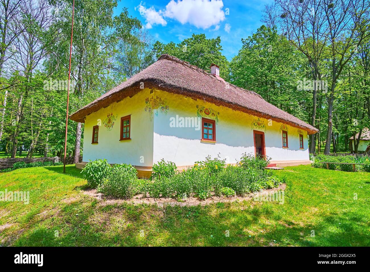 Le petit jardin en face de la maison hata blanchie à la chaux du gardien, décoré avec un motif floral peint à la main, Pereiaslav Scansen, Ukraine Banque D'Images