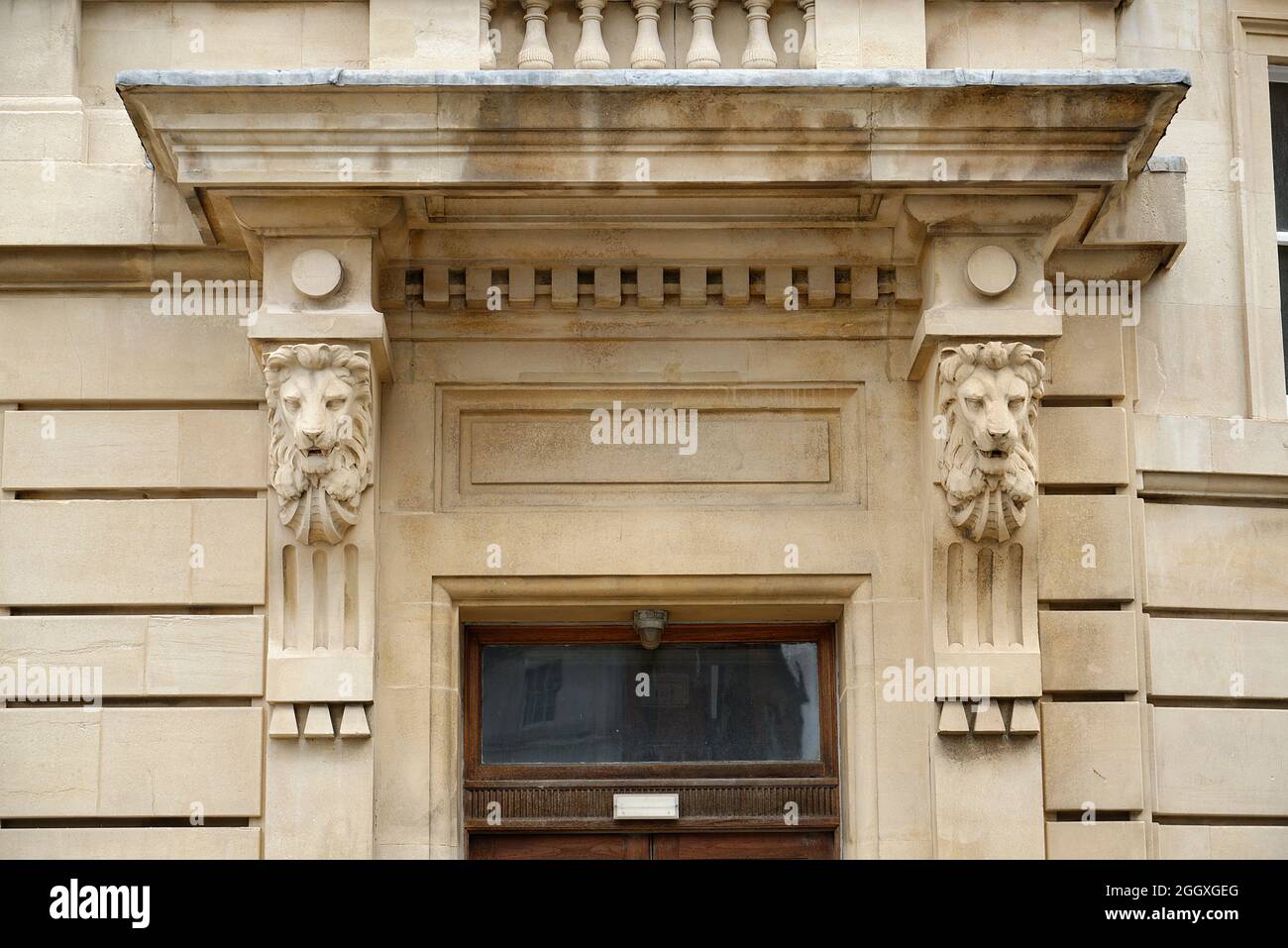Une grande entrée à un bâtiment en pierre. Têtes de lions de grès sculptées. Banque D'Images
