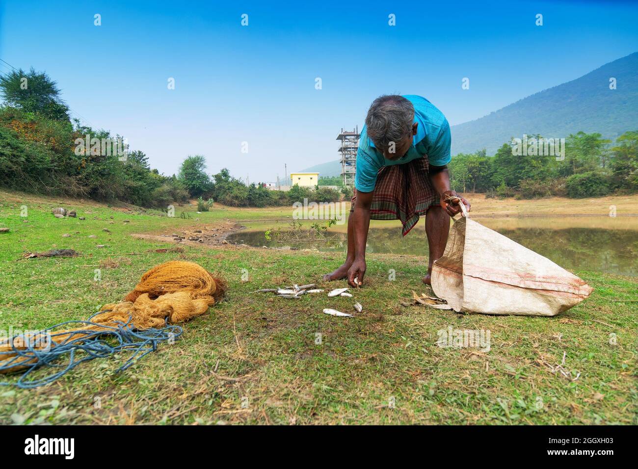 Gar Panchkot, Purulia , Bengale-Occidental, Inde - 23rd décembre 2015 : Un pêcheur solitaire comptant les poissons capturés de l'étang. Inde ayant de nombreux étangs . Banque D'Images