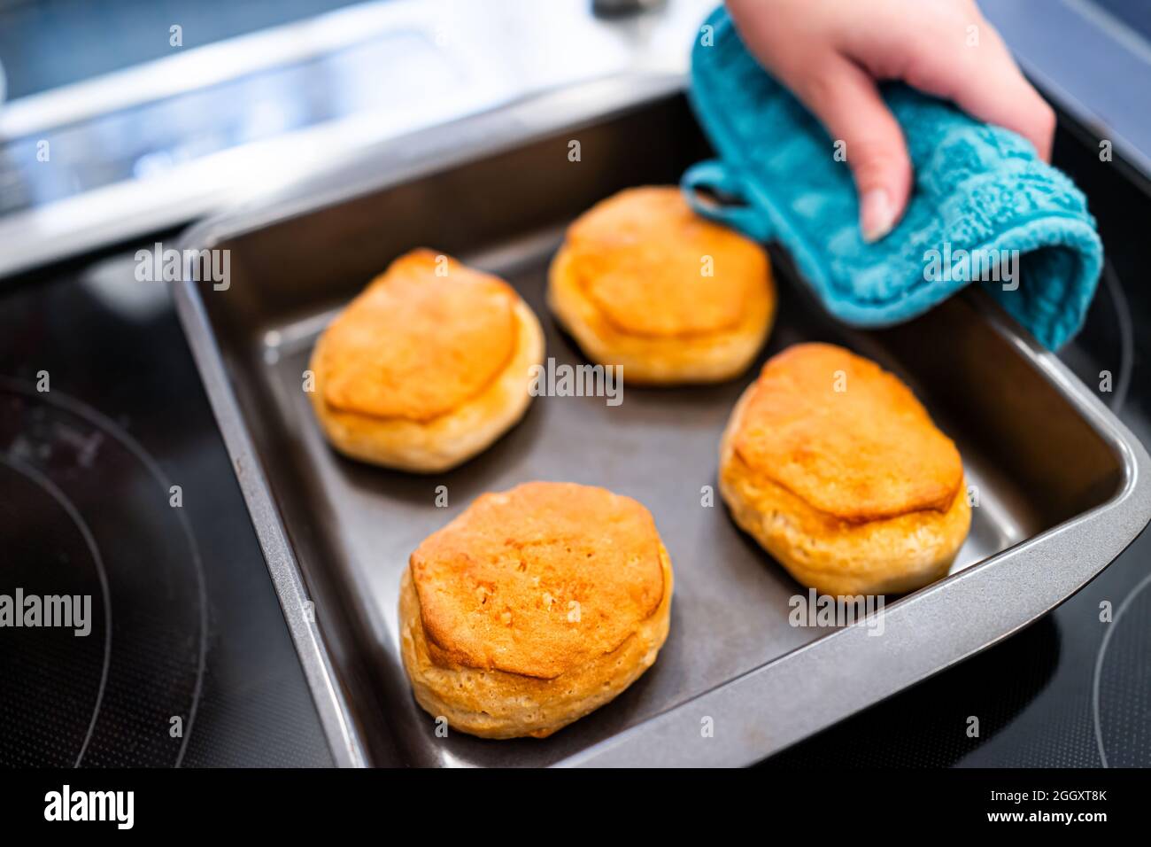 Plateau de cuisson frais servant des biscuits au babeurre avec des mets à la main et au four mitt après la cuisson pour le petit déjeuner traditionnel du sud le matin Banque D'Images
