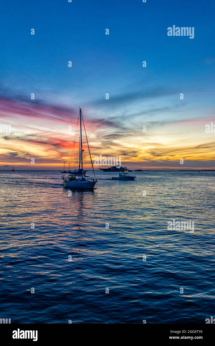 Silhouettes de bateaux yachts au coucher du soleil coloré crépuscule heure bleue avec vue verticale sur le paysage bleu ciel nuageux avec des nuages par la place Mallory de Key Banque D'Images