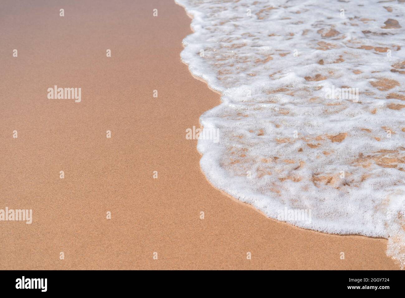 Mousse de mer sur sable doré texture arrière-plan vue de dessus pas de gens. Ocean Waves sur plage de sable humide concept de vacances Banque D'Images