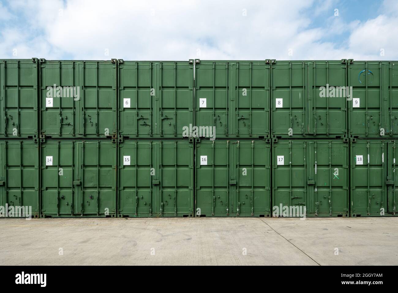 Rangée de conteneurs de stockage, grands conteneurs d'expédition verts empilés sur deux hauts et numérotés Banque D'Images