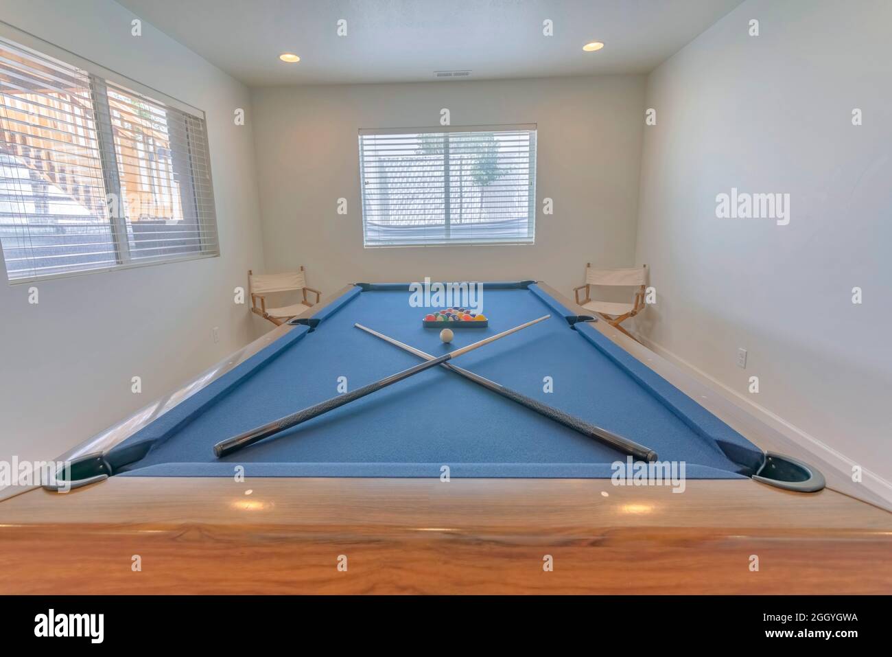Table de billard bleue avec queues de billard croisées et boules de billard Banque D'Images