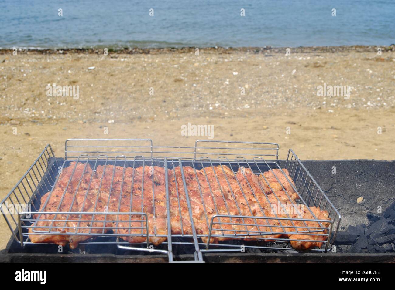 Barbecue sur la plage. La viande marinée est frite sur des coals chauds, trempés dans de la fumée parfumée. Mise au point sélective. Banque D'Images