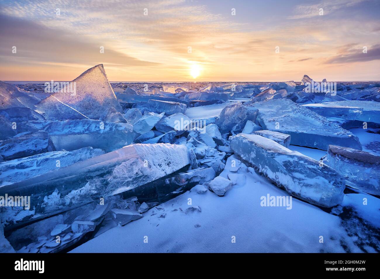 Magnifique coucher de soleil paysage de glace hummock et fissures au lac gelé Baikal, Russie Banque D'Images