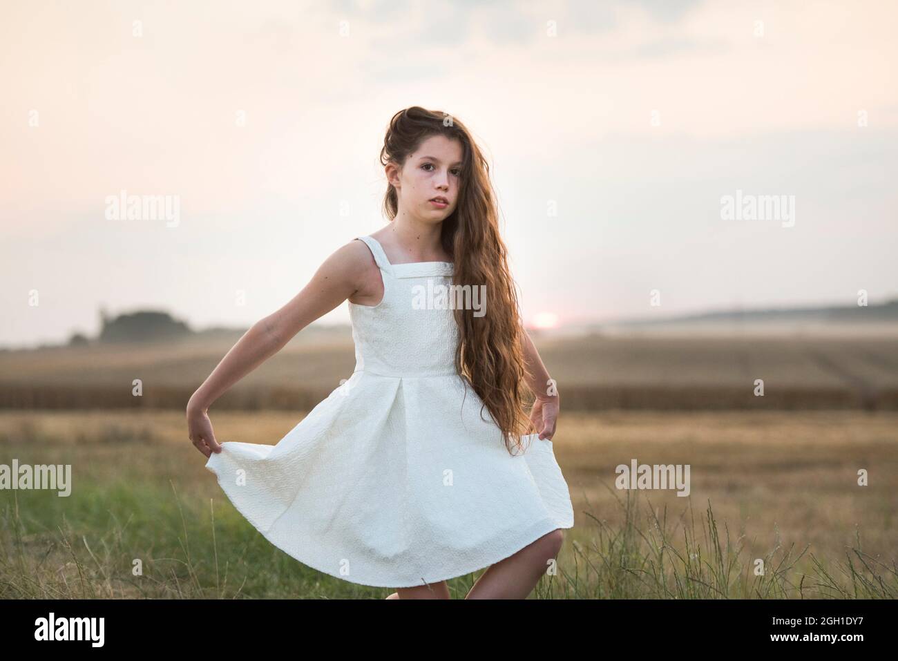 Fille en robe blanche essayant une révérence sur un sentier de campagne au  coucher du soleil, France, Europe Photo Stock - Alamy