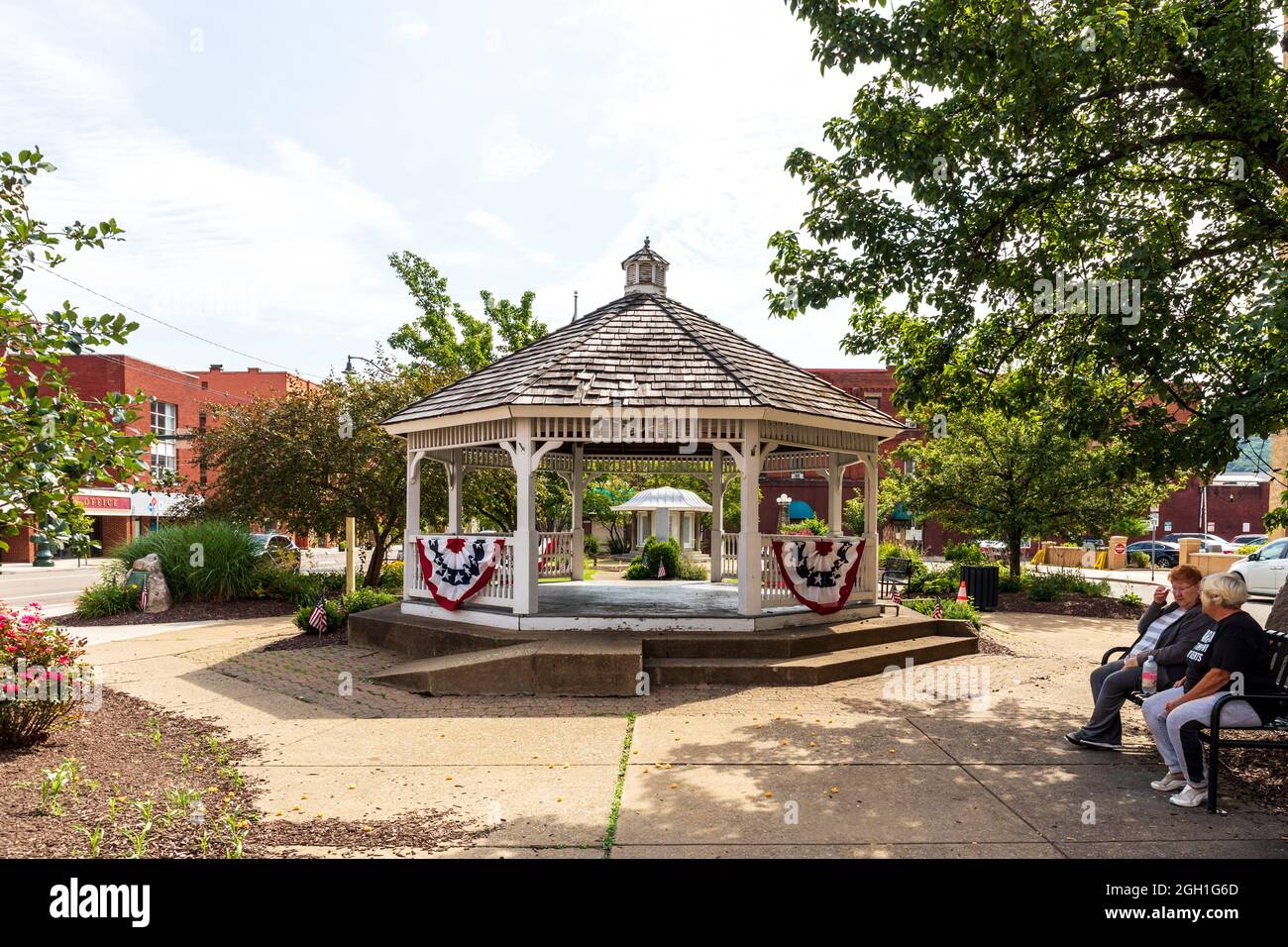 BRADFORD, PA, USA-13 AOÛT 2021: Un parc municipal, avec un belvédère et deux femmes assises sur un banc. Banque D'Images