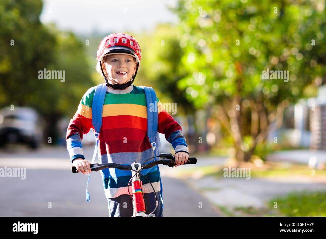 Enfant allant à l'école à vélo. Les enfants font du vélo. Moyen sûr de se  rendre à l'école primaire. Petit garçon avec sac à dos sur vélo rouge  portant un casque de