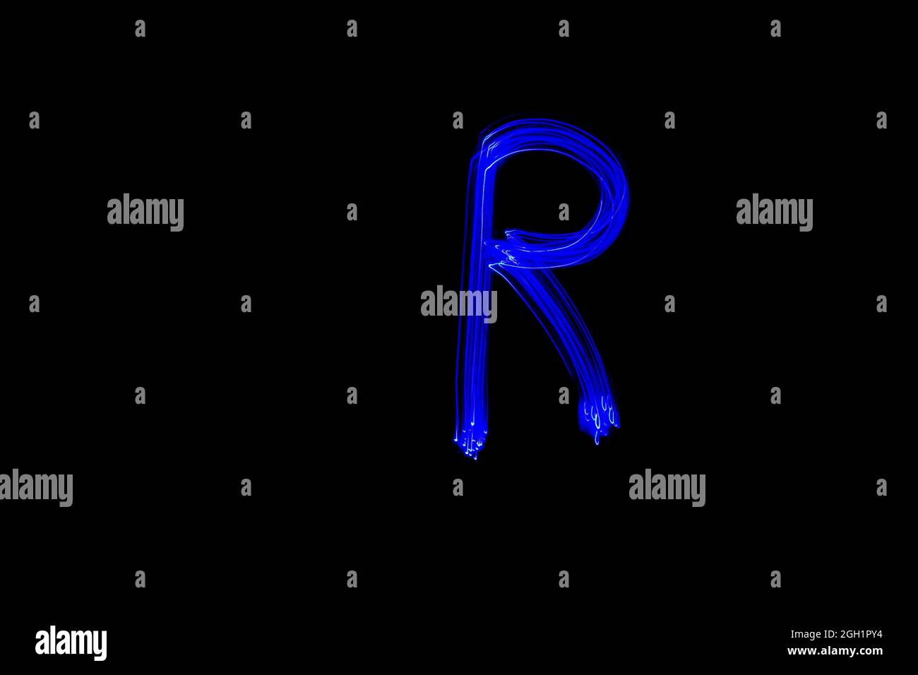 Lettre R. lettre peinture alphabet clair. Photographie en exposition prolongée. Dessin de la lettre R avec des lumières bleues sur fond noir. Banque D'Images
