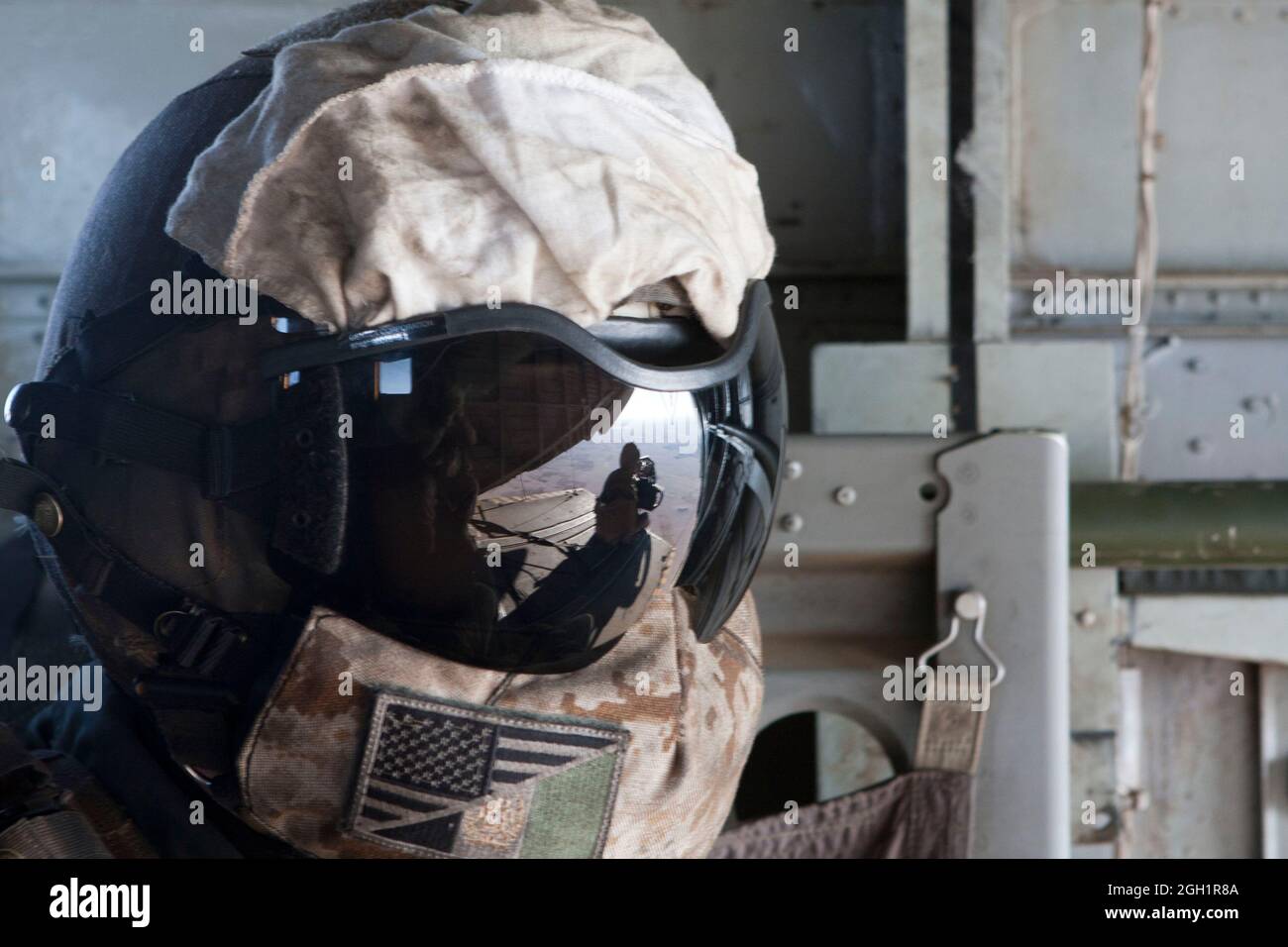Caporal du corps des Marines des États-Unis Zachary Hughes, instructeur de tactique d'armement, Escadron d'hélicoptères lourds maritimes 363, observe le Cpl lance. Madison DeLoach exploite une mitrailleuse de calibre 50, dans la vallée de la rivière Helmand, province de Helmand, Afghanistan, le 5 janvier, 2011. DeLoach a actionné la mitrailleuse de calibre .50 pendant les opérations de vol avec la direction de Hughes.p Banque D'Images