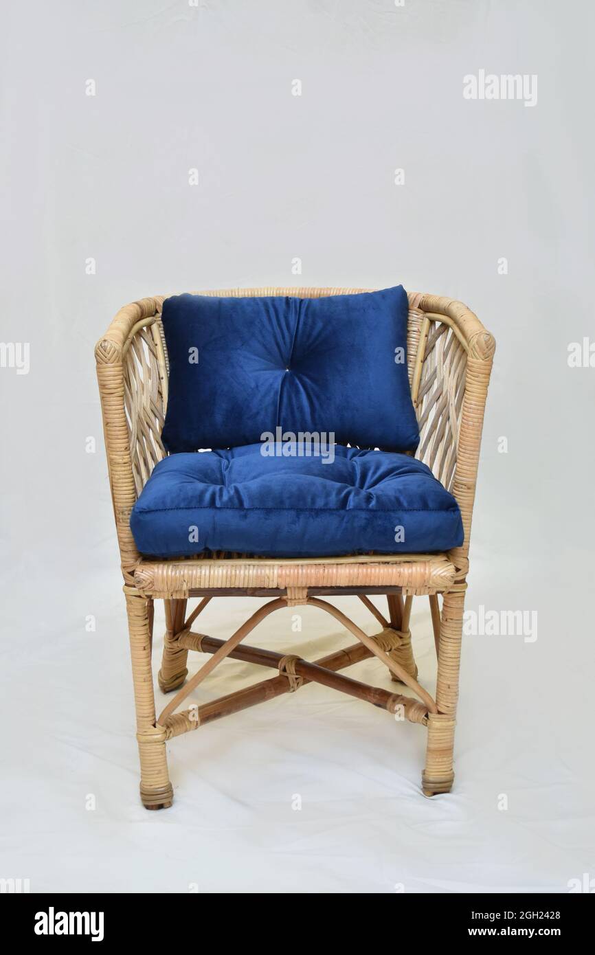 chaise de salle à manger en rotin avec coussin bleu sur fond blanc, mise au point douce sélective Banque D'Images