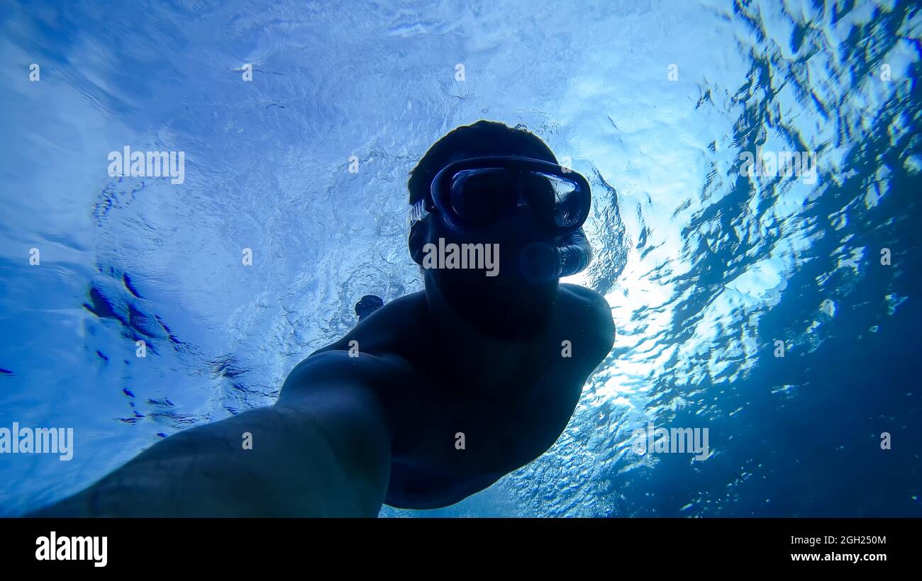 la silhouette d'un homme qui a plongé au fond de la mer rouge Banque D'Images