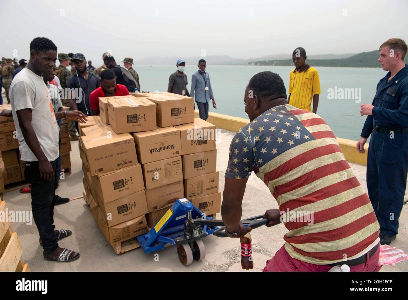 Des marins américains, des marins et des bénévoles ont déchargé des vivres d'un embarcation au port de Jeremie lors d'une mission humanitaire le 31 août 2021 à Jeremie, en Haïti. L'armée, l'USAID et les volontaires participent à la suite du récent tremblement de terre. Banque D'Images