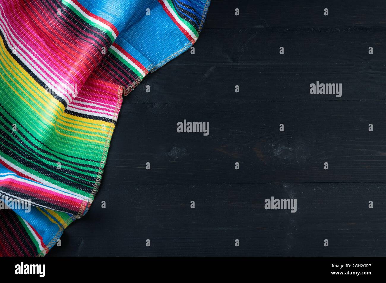 Poncho mexicain coloré sur fond noir. Copier l'espace. Typique du Mexique. Banque D'Images