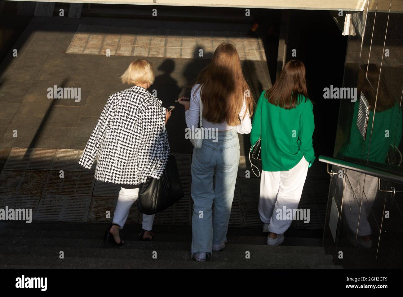 Moscou, Russie - 31 août 2021, trois filles habilement habillées et méconnaissables descendent les escaliers jusqu'au passage souterrain Banque D'Images
