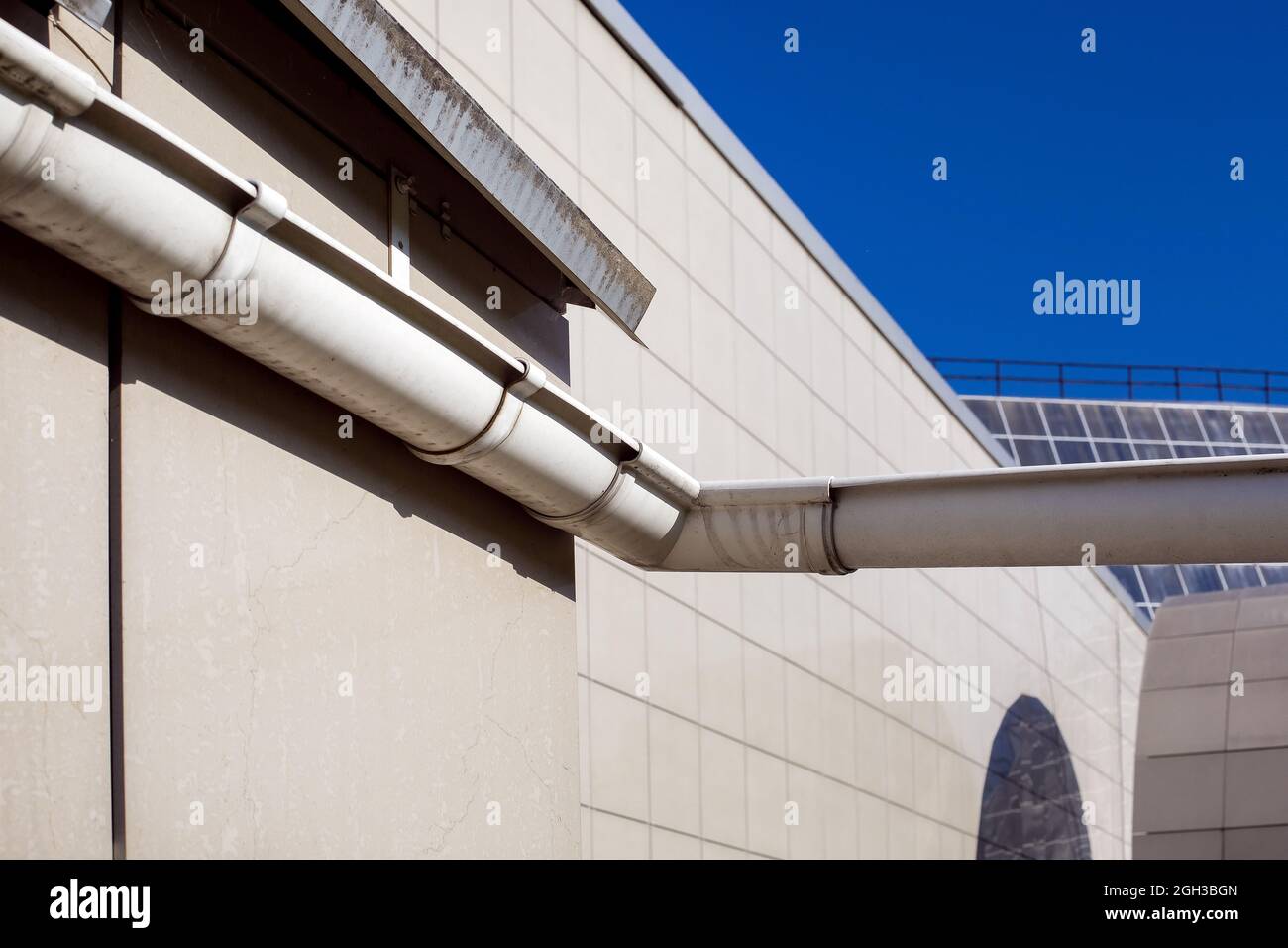 gouttière de drainage pour drainer l'eau de pluie du toit d'une façade de maison carrelée sur une journée ensoleillée extérieur de gros plan. Banque D'Images